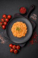 Delicious fresh pasta consisting of thin noodles, red pesto rosso sauce with spices and herbs photo