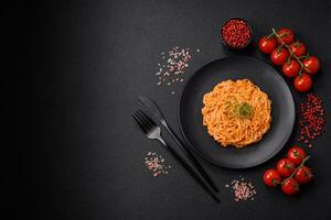 Delicious fresh pasta consisting of thin noodles, red pesto rosso sauce with spices and herbs photo