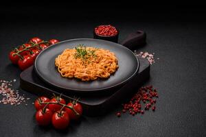 Delicious fresh pasta consisting of thin noodles, red pesto rosso sauce with spices and herbs photo