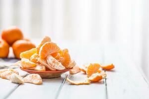 Fresh pieces of tangerines mandarin on the plate or in a bowl photo