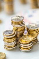 Euro banknotes and coins togetger on white table - close-up photo
