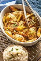 Chicken legs roasted with american potatoes in baking dish photo