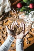 Navidad horneando y pan de jengibre corazón en mujer manos foto