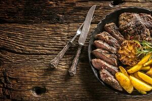 Grilled beef Rib Eye steak with garlic american potatoes rosemary salt and spices photo