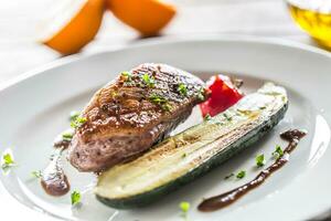 Roasted duck breast with zucchini tomato and parsley herbs photo
