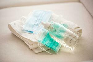 Coronavirus prevention concept - Surgical travel masks hand disinfectant gel and and towel photo