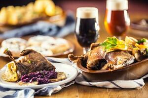 Roasted christmas duck leg red cabbage dumplings liver draft beer and baked buns photo