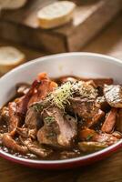 Roast wild boar with carrot mushrooms, baguette and draft beer photo