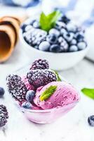 Blueberry and blackberry ice cream in bowl with frozen fruits photo