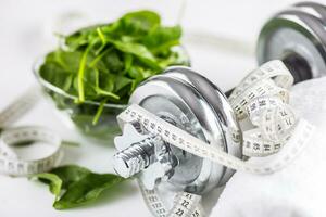 Spinach dumbbells and measure tape isolated on white background photo