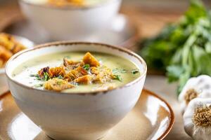 Garlic cream soup with bread croutons in bowl photo