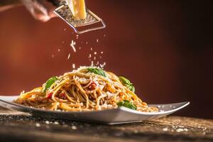 Italian pasta spaghetti with tomato sauce basil and parmesan cheese in white plate photo