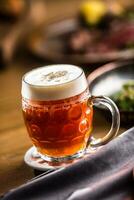 Draft beer with foam on bar counter in pub. photo