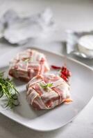 Cheese wraps preparation by wrapping them in a bacon slices griddle before baking photo