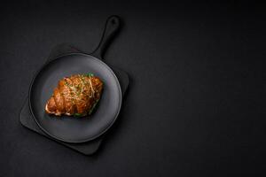 Delicious crispy croissant with salmon, lettuce, cheese and tomatoes photo