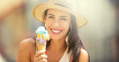 Portrait of a beautiful young woman eating ice cream during a hot summer day photo