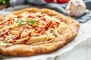 Deep-fried tastyful hungarian cheesy langos with poured ketchup, herbs and garlic photo