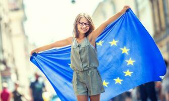 linda contento joven niña con el bandera de el europeo Unión foto