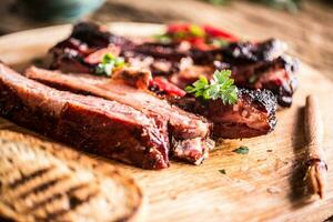 Tasty barbecue grilled pork ribs with chili pepers and parsley herbs. photo