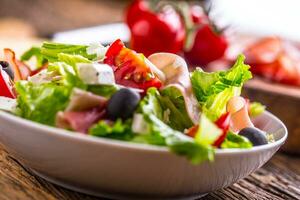 Salad. Fresh summer lettuce salad.Healthy mediterranean salad olives tomatoes parmesan cheese and prosciutto. photo