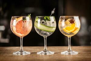 Gin tonic long drink as a classic cocktail in various forms with garnish in individual glasses such as orange, grapefruit, or cucumber photo