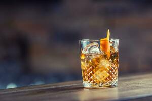 Old fashioned classic cocktail drink in crystal glass on bar counter. photo