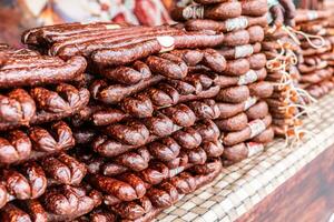 Various types of smoked sausages piled up for sale in the market. photo