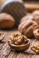 Walnut. Walnut kernels and whole walnuts on rustic old oak table photo