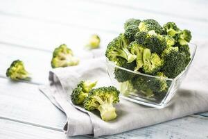 Fresh broccoli in bowl on wooden table photo