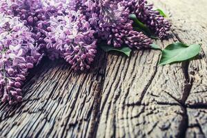 Bouquet of purple lilac on old wooden table photo