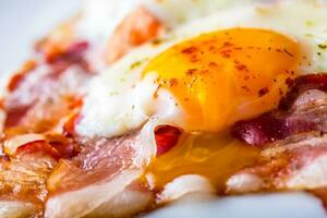 Ham and Eggs. Bacon and Eggs. Salted egg and sprinkled with red pepper. English breakfast. photo