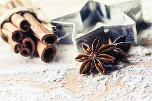 Star anise cookie cutter cinnamon and flour on baking board. Christmas baking utensil and holiday concept photo