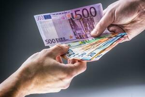 Male hands holding euro banknotes and the other hand to receive a bribe photo