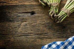 Fresh green asparagus on old oak table photo