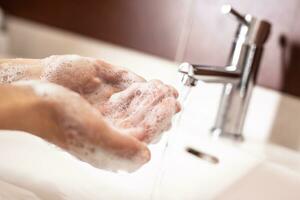 Lavado manos con agua y líquido jabón en el baño. higiene antivirus concepto foto