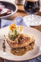 Rabbit leg with mashes potatoes and decoration on plate in restaurant photo