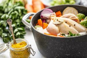 Chicken ready to cook broth with fresh root vegetables and spices photo