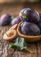 Plums. Fresh juicy plums in a bowl on a wooden or concrete board photo