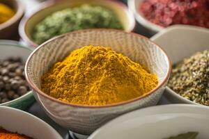 Curry and variety spices and herbs in bowls photo