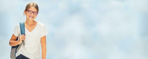 Portrait of modern happy teen school girl with bag backpackand on blurred background. photo