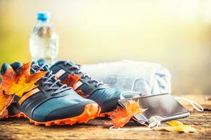 Blue sport shoes and water laid on a wooden board. photo