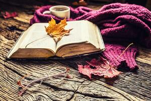 Cup of coffee old  book glasses and autumn leaves. photo