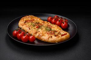 Delicious oven fresh flatbread pizza with cheese, tomatoes, sausage, salt and spices photo