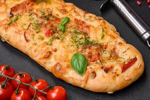 Delicious oven fresh flatbread pizza with cheese, tomatoes, sausage, salt and spices photo