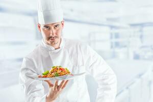 Chef in restaurant kitchen holding plate with italian meal spaghetti bolognese photo
