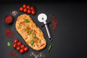 Delicious oven fresh flatbread pizza with cheese, tomatoes, sausage, salt and spices photo