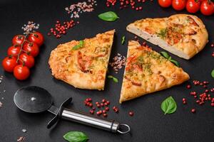 Delicious oven fresh flatbread pizza with cheese, tomatoes, sausage, salt and spices photo