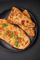 Delicious oven fresh flatbread pizza with cheese, tomatoes, sausage, salt and spices photo