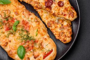 Delicious oven fresh flatbread pizza with cheese, tomatoes, sausage, salt and spices photo