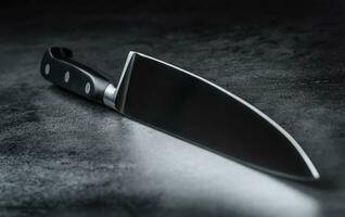 Kitchen knife lying on an modern concrete cutting board. photo